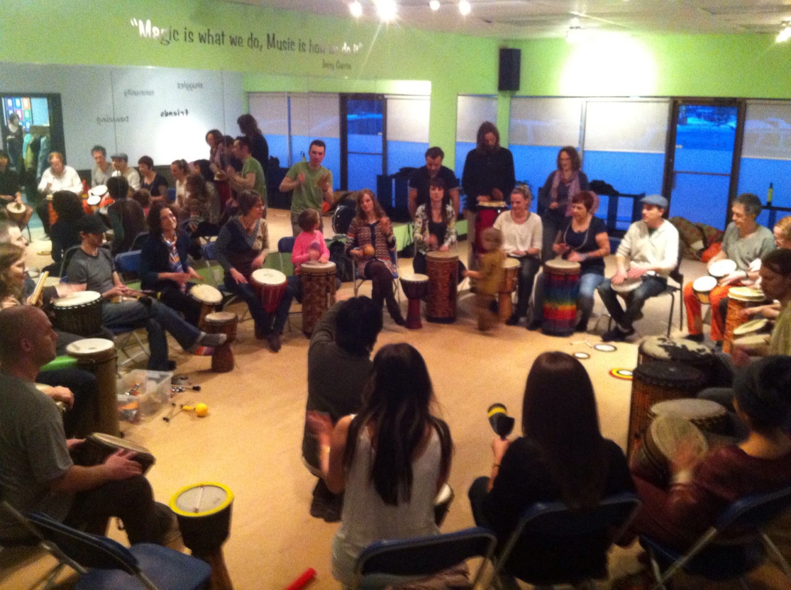 A large community drum circle filling a room