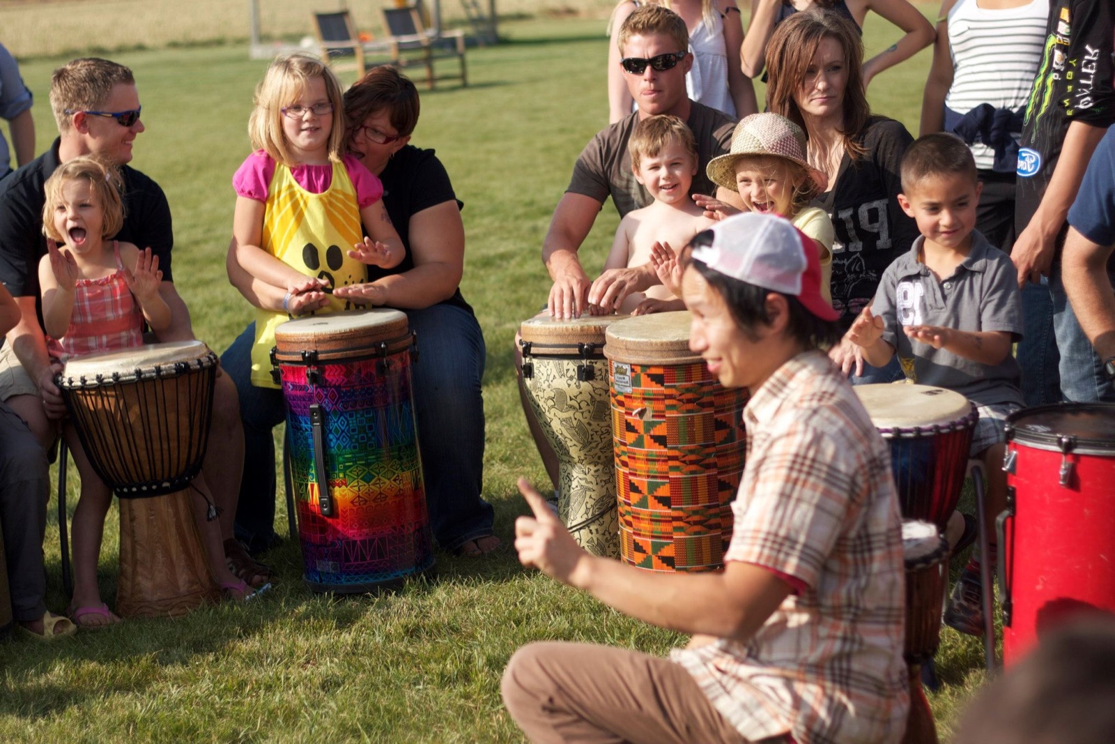 Marcus Fung leading families and kids at the drums in an outdoor drum circle